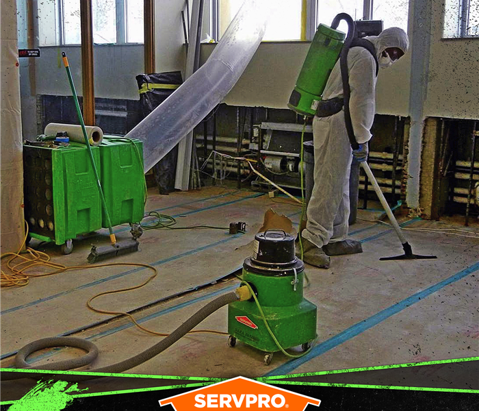 SERVPRO tech wearing protective gear in a home using equipment to clean and purify the air and surfaces.